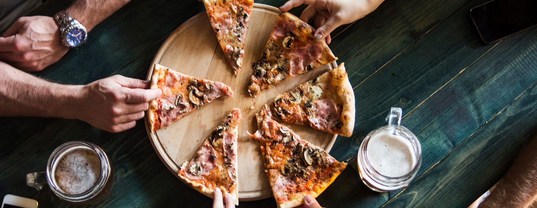 Friends enjoying a large pizza 