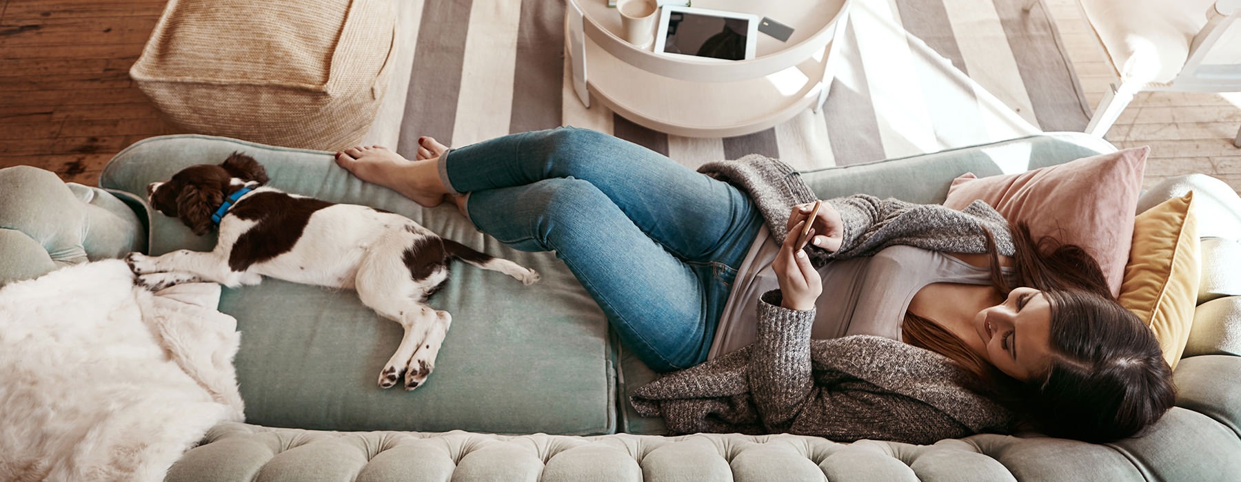 Woman laying on the couch with her dog 