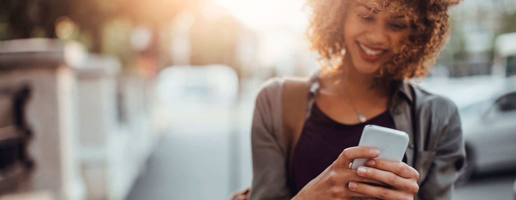 Woman walking down the street looking at her phone 